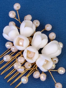 Detail of handcrafted bridal hair comb with ceramic flowers, pearls and golden wires