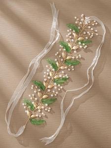 Macro detail of bridal hair vine with golden leaves, green beads and white pearls