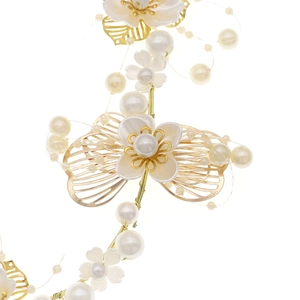 Gros plan du bandeau fait main avec fleurs blanches, perles et feuilles dorées