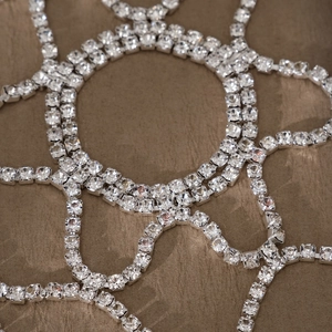 Macro detail of silver layered head chain with sparkling square-cut rhinestones