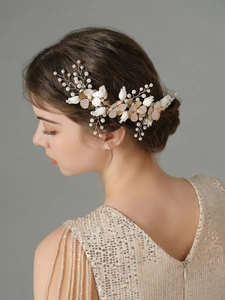 Dettaglio di un cerchietto da sposa fatto a mano con fiori di ceramica, perle e foglie