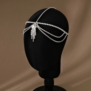 Detailed close-up of exotic silver rhinestone head chain with layered tassels and gemstone