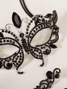 Détails du masque papillon serti de strass noirs et de ses boucles d'oreilles