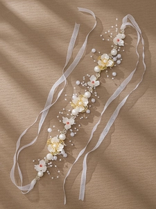 Détail d'un bandeau floral fait main avec perles et cristaux de cœur rouges sur organza
