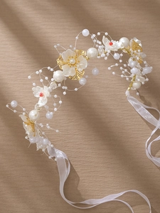 Détail d'un bandeau floral fait main avec perles et fleurs en acrylique sur ruban