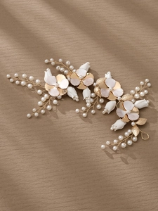 Dettaglio ravvicinato di cerchietto da sposa con fiori di ceramica bianca e perle dorate