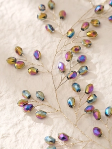 Gros plan d'une vigne de cheveux dorée avec des perles en cristal irisées