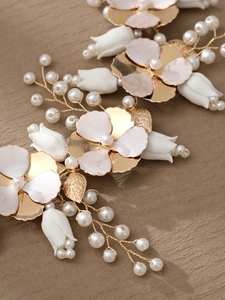 Dettaglio di cerchietto sposa con tulipani in ceramica, petali dorati e perle su tessuto