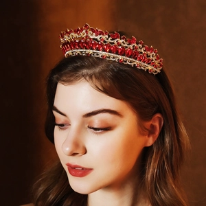 Close-up of golden bridal crown with marquise red rhinestones and white crystals
