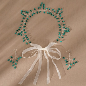 Detail of green marquise rhinestone headband and earring set on textured surface