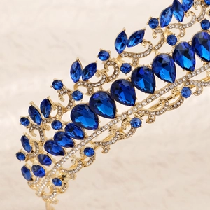 Close-up of a golden bridal tiara with luxury blue teardrop rhinestones and fine details