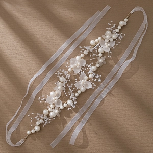 Détail d'un ruban de cheveux fait main avec perles blanches et fleurs en acrylique givré