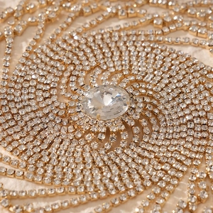 Macro shot of gold spiral rhinestone hair accessory with large oval center crystal