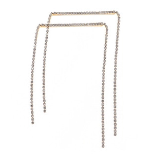 Detail of gold U-shaped tassel hair clip with sparkling white rhinestones and fringe