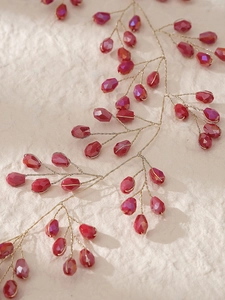 Détail d'une vigne de cheveux en fil doré faite main avec perles de cristal rouge