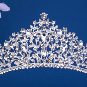 Detailed view of silver bridal crown with intricate crystal rhinestones on blue background