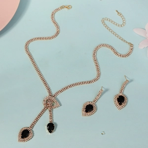 Parure de bijoux dorés avec collier et boucles d'oreilles sertis de cristaux noirs chics