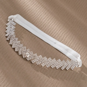 Detailed view of handmade bridal garter with rhinestones and white elastic band