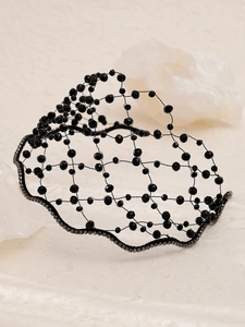 Macro detail of handmade black beaded headband with sparkling crystals and woven frame