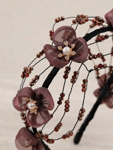 Detailed macro view of handmade floral headband with crystal beads and organza flowers
