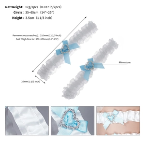 Detail view of elastic white lace bridal garter set with blue bows and heart rhinestones
