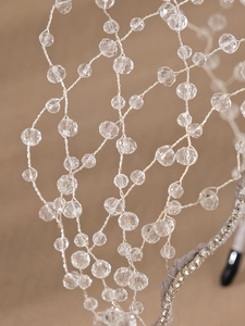 Macro detail of hand-woven silver wire headpiece with crystal beads and rhinestones