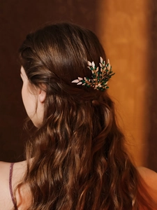 Close-up of vintage bridal hair comb with green marquise rhinestones and pearls on hair