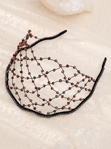 Macro view of handmade mesh bridal headband with red and brown crystal beadwork details