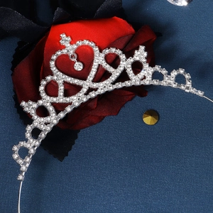 Detalle de diadema de corona de strass plateada con diseño de corazón en azul oscuro