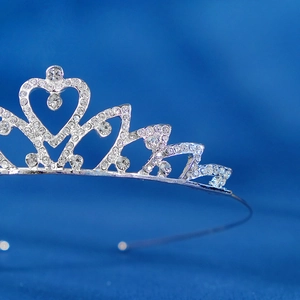 Close-up detail of silver rhinestone crown with heart design for girl princess parties