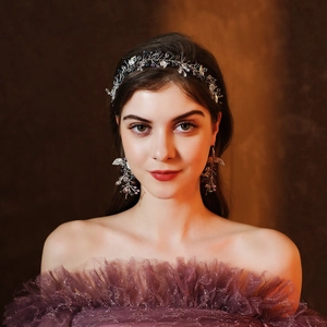 Close-up of bridal headband and earring set with purple crystals and silver leaves