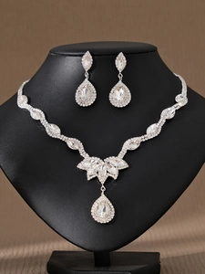 Detalle del conjunto de joyas de novia plateadas con cristales y colgantes de gota