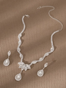 Detalle de un conjunto de joyas de novia vintage con pedrería de pera y acabado plateado