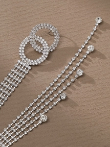 Gros plan de boucles d'oreilles à pompons argentés avec strass et cercles entrelacés