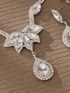 Detalle de conjunto plateado con cristales talla marquesa y pera en collar y pendientes