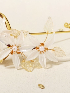 Detail of bridal hair comb with resin flowers, pearls, and golden metal wires