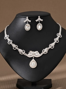 Vista detallada de un conjunto de joyas de novia plateadas con brillantes piedras de cristal