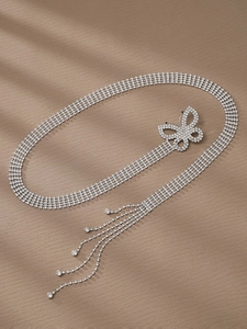Détail de la ceinture en cristal argenté avec pendentif papillon et pompons