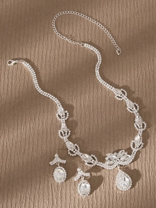 Vista plana de conjunto de joyería nupcial de plata con diamantes de imitación y gota