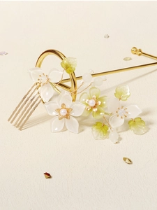 Detailed macro view of resin flower hair comb with cream pearls and green accents