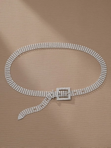 Détail d'une ceinture à quatre rangées de strass avec boucle carrée sur fond brun