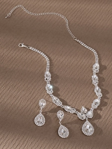 Vista detallada de un conjunto de joyas de novia plateadas con cristales y pendientes