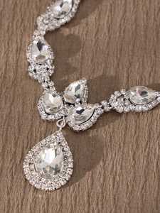 Primer plano de collar de novia plateado con cristales de pera y detalles de micro-pavé finos
