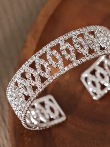 Macro-opname van zilveren geometrische opengewerkte armband met glanzende strass