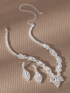 Detalle de conjunto de joyas de novia plateadas con piedras marquesa y cristales finos
