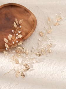Détails d'un bandeau de mariée fait main avec feuilles dorées et perles blanches