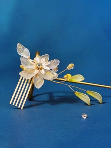 Detail of golden floral hair comb with translucent petals and sparkling rhinestones