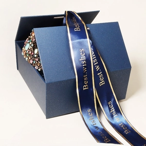 Detailed view of luxury navy blue jewelry gift box with a sparkling crystal crown inside