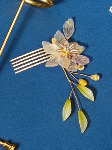 Detail of bridal hair comb with resin petals, gold foil accents and beaded tassels