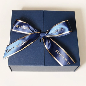 Macro shot of dark blue matte gift box with a satin ribbon and golden Best Wishes print